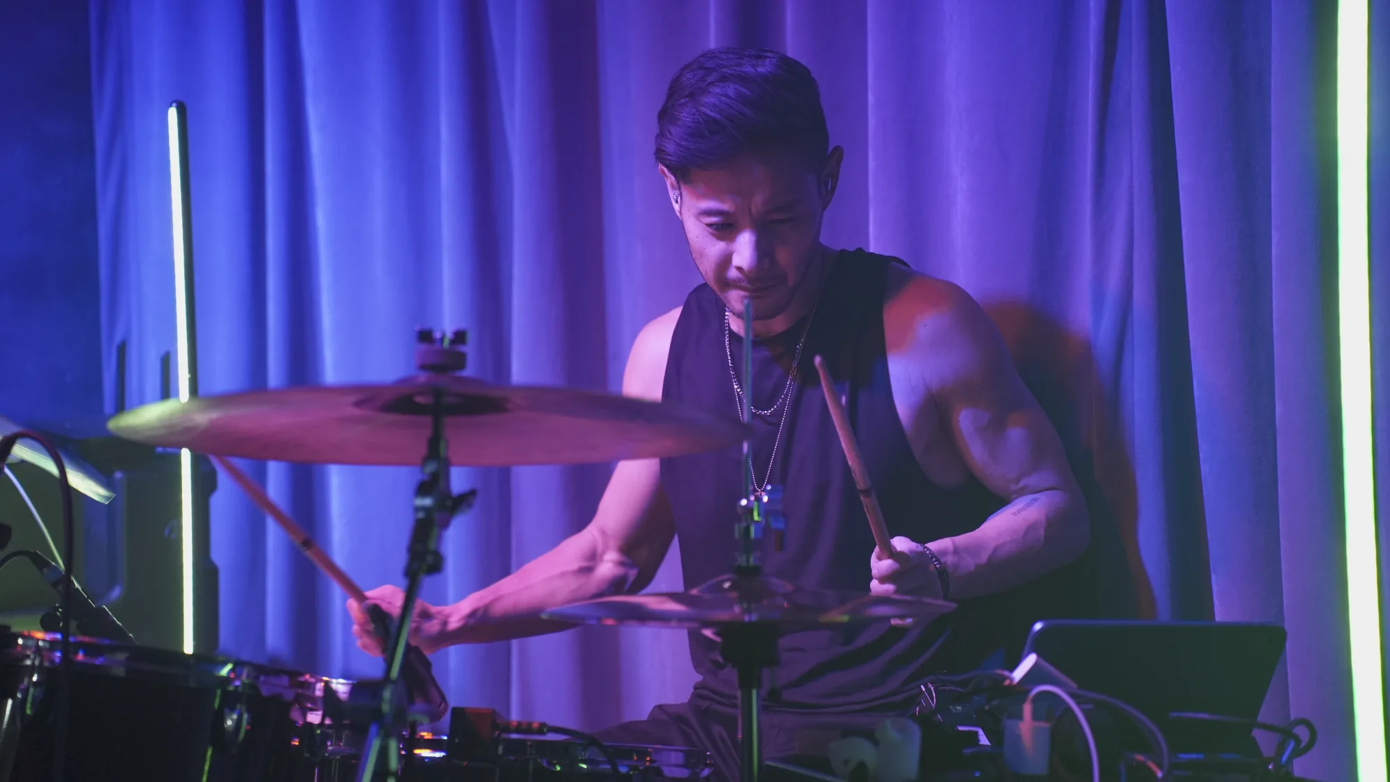 Drummer performing under blue and violet stage lights